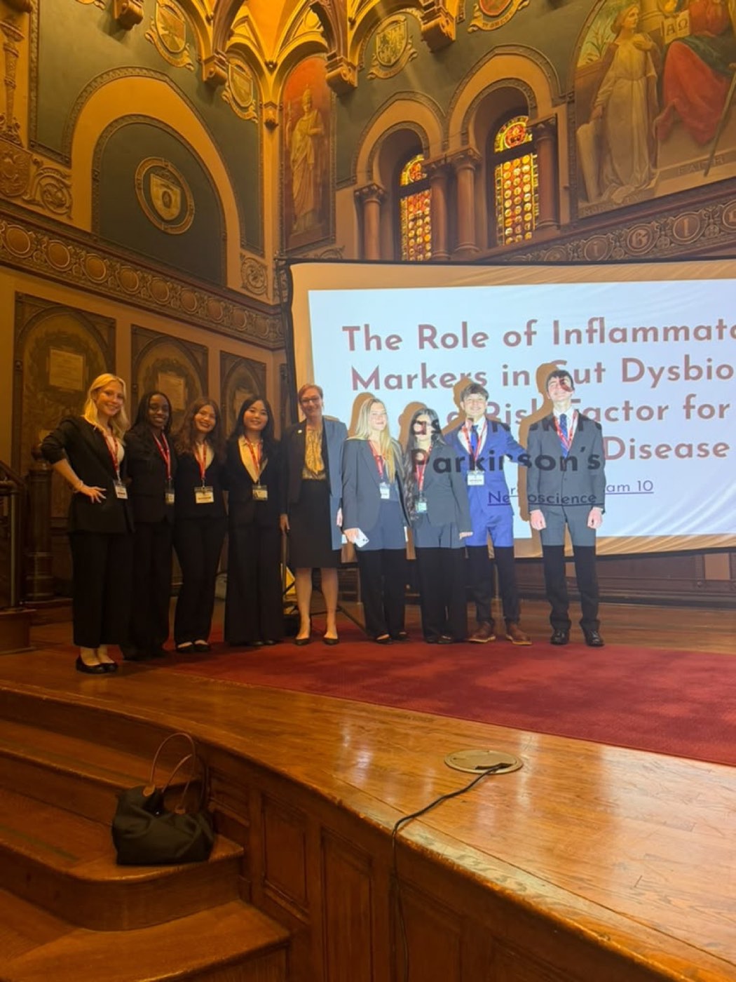 Daniel's research team in front of their presentation title slide